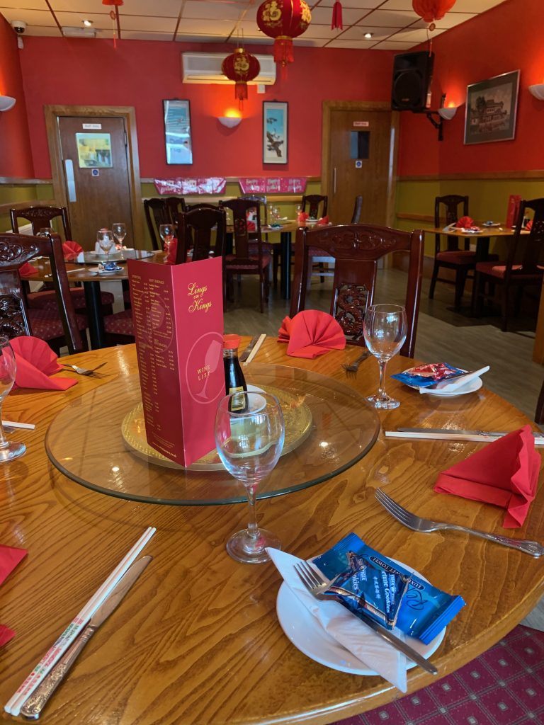 A table set with red napkins and wine glasses at Lings on Kings